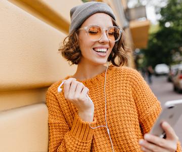 women-in-orange-enjoying-music-with-a-phone-in-hand